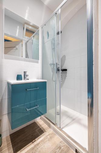une salle de bain avec un lavabo bleu et une douche dans l'établissement Large Studio 100m from the beach, à Nice