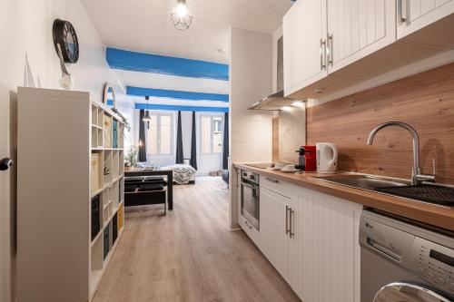 une cuisine avec des armoires blanches et un évier dans l'établissement Large Studio 100m from the beach, à Nice