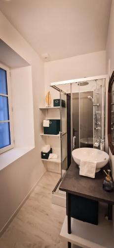une salle de bain avec un lavabo et une douche en verre dans l'établissement L'Art Déco 3 étoiles Wifi, Netflix, Disney, Coeur de Bastide, à Villefranche-de-Rouergue