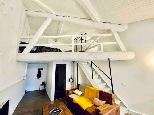 uma sala de estar com um sofá e uma cama alta em Appartement sous les toits em Narbona
