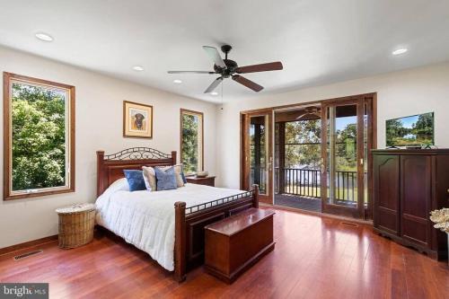 una camera con letto e ventilatore a soffitto di For a private, stunning vacation home or retreat a Lancaster