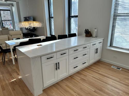 a kitchen with a large white island in a living room at Luxe Spacious SFH in Bucktown with Secure Parking in Chicago