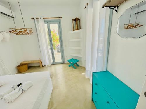 1 dormitorio con 1 cama y vestidor azul en VILLA THEIA - SELENE , appartement de charme pour 4 à 6 personnes prés de la plage et du village de Koufonissi, en Koufonisia