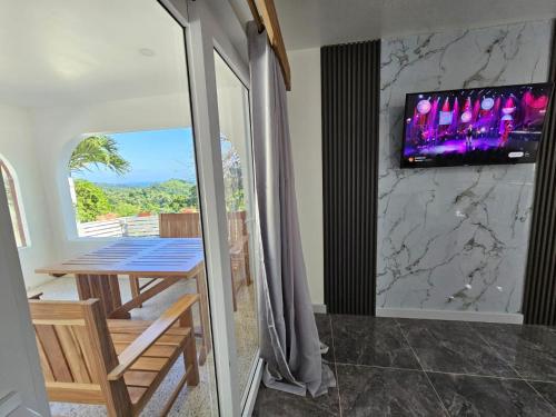 a dining room with a table and a tv on a wall at Casa Margarita in First Bight