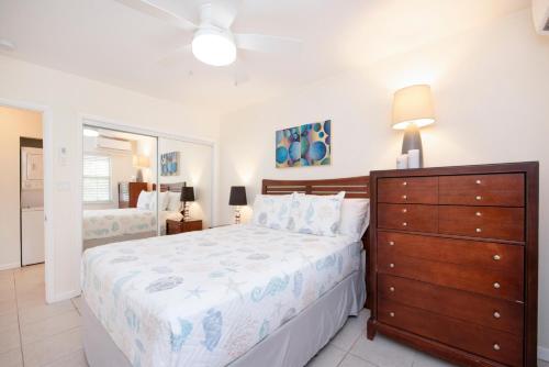 a bedroom with a large bed and a dresser at Snug Harbour View Condo #3 in George Town