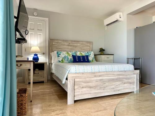 Schlafzimmer mit einem Bett, einem Schreibtisch und einem TV in der Unterkunft Seven Mile View Condo 3A in West Bay