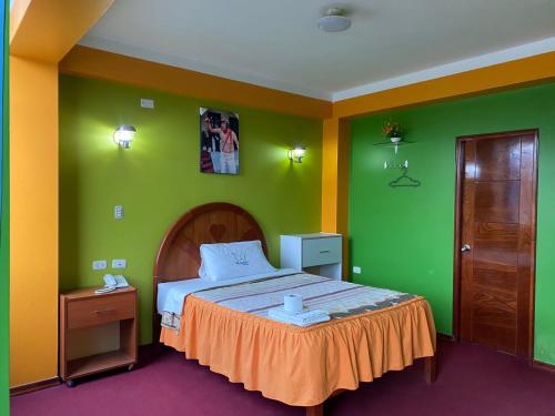 um quarto com uma cama com paredes em verde e laranja em HOTEL TURISTICO EL OSCAR em Cutervo