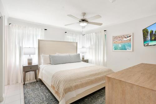 a white bedroom with a bed and a ceiling fan at Coconut Bay Villas #113 in George Town