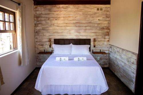 a bedroom with a bed with two candles on it at Encanto Paraty Beach in Paraty