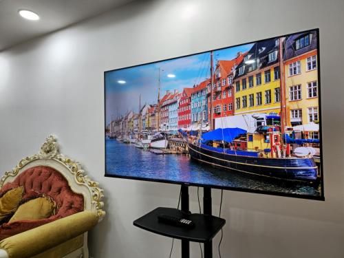 telewizor z płaskim ekranem wiszący na ścianie w obiekcie Luxury Apartment - Beach Tower 2 w Szardży