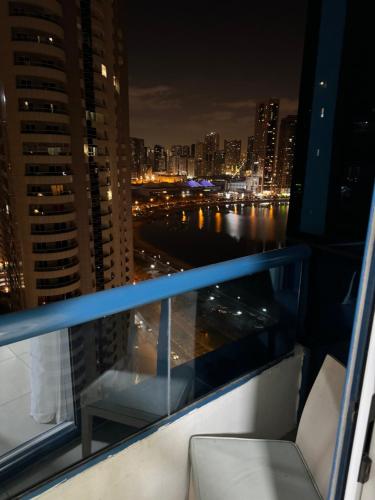 a balcony with a view of a city at night at Luxury Apartment - Beach Tower 2 in Sharjah