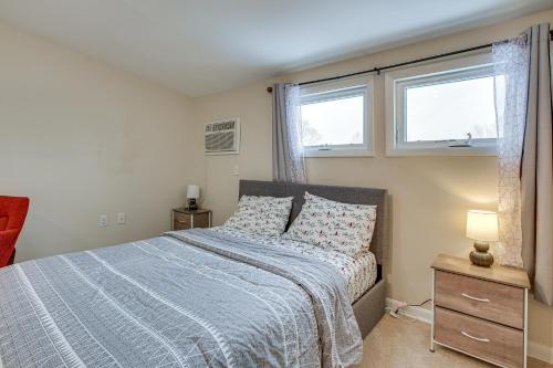 a bedroom with a bed with a blue comforter and two windows at Wilmington Vacation Rental Less Than 2 Mi to Downtown! in Wilmington