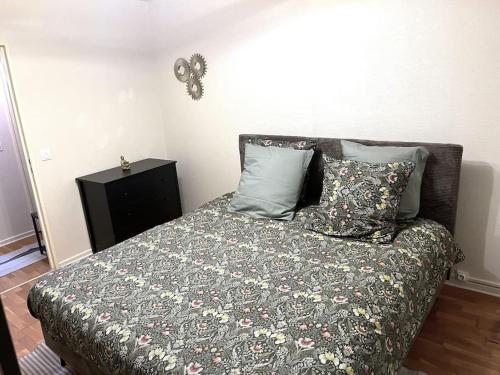 - un lit avec une couverture et des oreillers dans l'établissement Charmant Appartement à Metz, à Metz