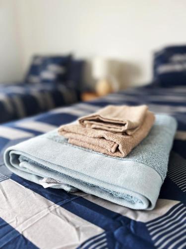 a pile of towels sitting on top of a bed at Auckland Birkenhead BNB in Auckland