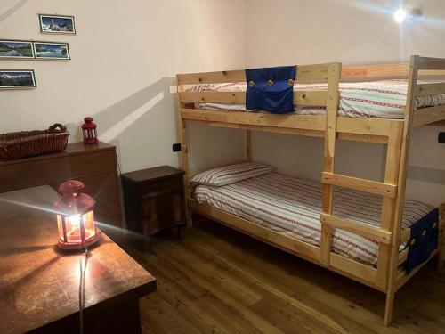Pokój z 2 łóżkami piętrowymi i świecą na stole w obiekcie Jack's House w mieście Courmayeur