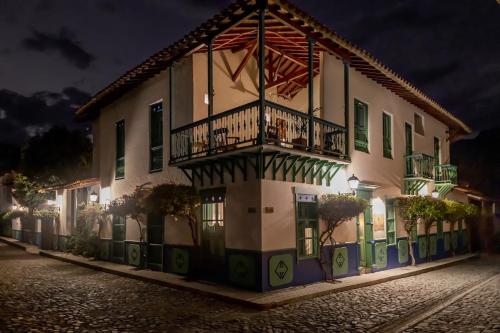 a building with a balcony with a flag on it at Casa Cedrela Hotel Boutique by HMC -Cauca Viejo- Mayores de 14 años in Jericó
