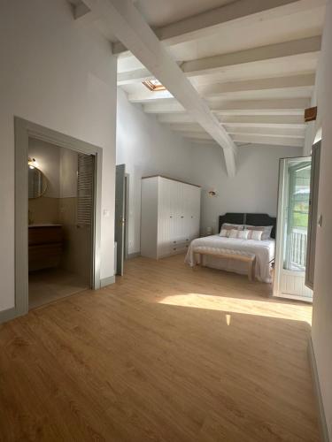Habitación blanca con cama y ventana en RUSTIC HOMES en San Vicente de la Barquera