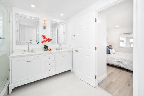 een witte badkamer met 2 wastafels en een bed bij Brand new Lower unit on the Beach with Patio and Firepit in Newport Beach