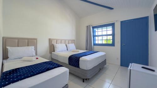 1 dormitorio con 2 camas y ventana en Pousada Vila Capri, en Búzios