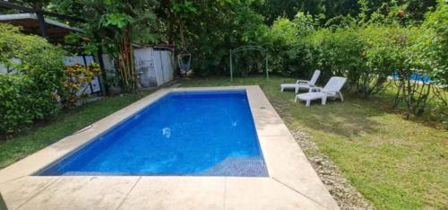 a small blue swimming pool with two chairs in a yard at Pura Vida Villa! Beachfront Golf and Country Club Los Delfines 24 hours security in Tambor
