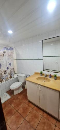 a bathroom with a toilet and a sink and a mirror at Pura Vida Villa! Beachfront Golf and Country Club Los Delfines 24 hours security in Tambor