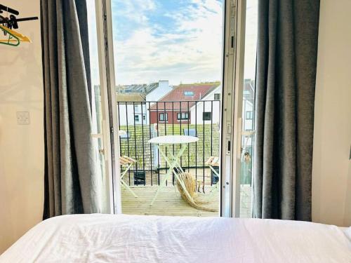 a bedroom with a bed and a view of a balcony at SeaView Apartment with Roof Terrace and Pool Table in Kent