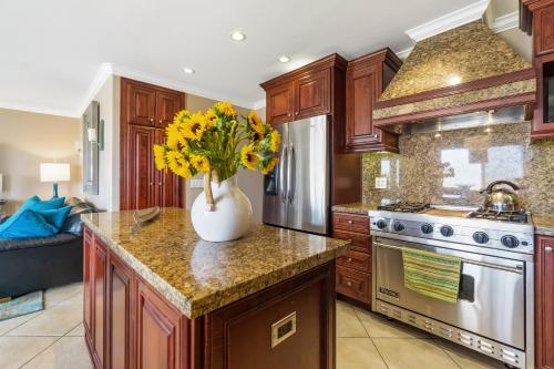a kitchen with a vase with yellow flowers on a counter at 2 Bedroom Home on the Beach with Ocean View in Newport Beach