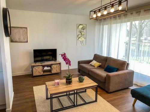 - un salon avec un canapé et une télévision dans l'établissement T3 Moderne avec balcon terrasse et parking gratuit, à Niort