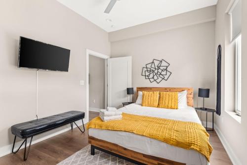 a bedroom with a bed and a flat screen tv at Mason Lofts at West End in Nashville