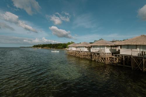 a row of huts on a pier over the water at Kaway Resort & Spa in Tabuelan