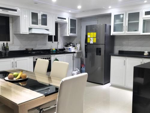 y cocina con mesa, sillas y nevera. en Apartamento en Santo Domingo, en Los Paredones