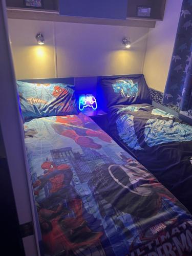 sypialnia z dwoma łóżkami z oświetleniem w obiekcie Cjs family caravans w mieście Ayr