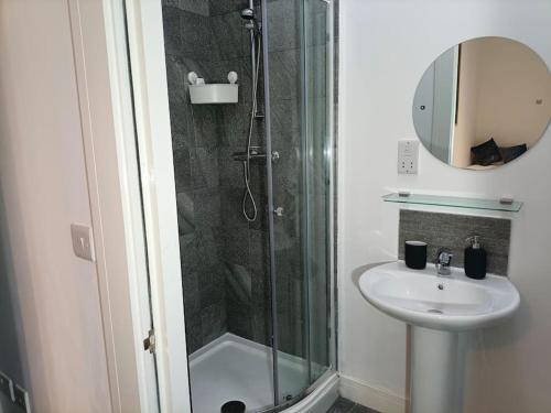 een badkamer met een douche en een wastafel bij Modern and Cosy 1 bedroom Apartment Close to Stadiums, Transport links, Free Parking in Manchester