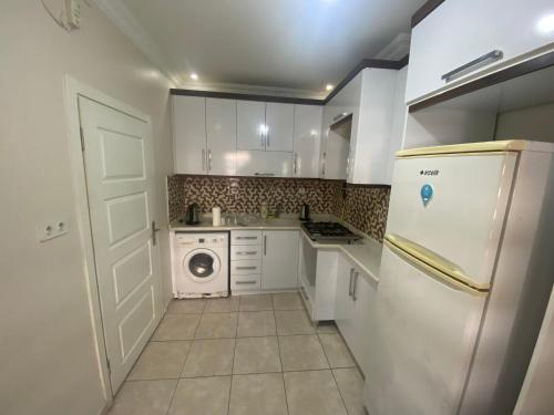 uma cozinha com um frigorífico branco e uma máquina de lavar roupa em Eylül suit otel em Yıldırım