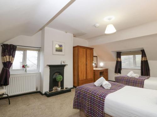 a bedroom with two beds and a fireplace at Cwm in Betws-y-coed