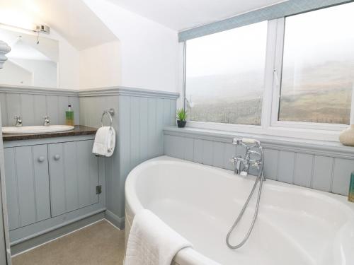 a bath tub in a bathroom with a window at Cwm in Betws-y-coed