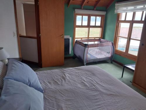 a bedroom with a bed in a room with windows at Horizonte Fueguino II in Ushuaia