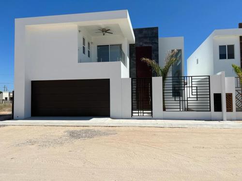 a white house with a gate and a driveway at CASA ESTRELLA in Puerto Peñasco