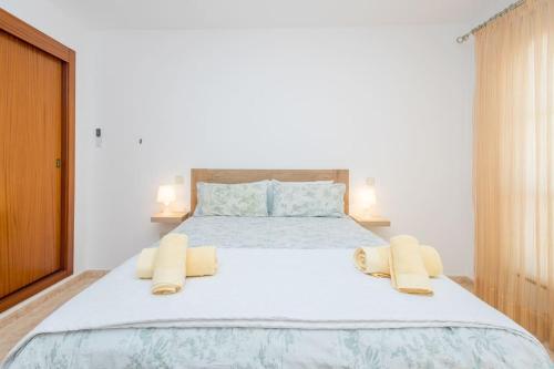 Un dormitorio con una cama grande con dos almohadas encima. en Ático con terraza en Agaete, en Agaete