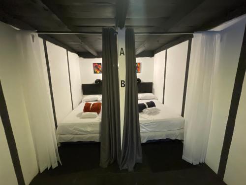 - 2 lits dans une chambre avec des rideaux blancs dans l'établissement Hostal de fiesta - Hostal Pub, à Antigua Guatemala