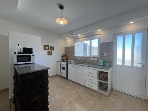 a kitchen with a sink and a microwave at Mar y Rio Duplex in Playa Unión
