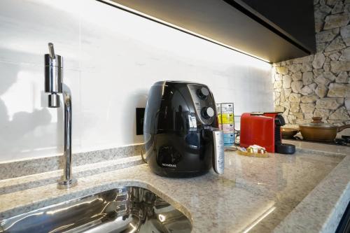eine Kaffeemaschine auf einer Küchentheke in der Unterkunft Loft de Luxo no Bairro mais nobre de Goiânia in Goiânia