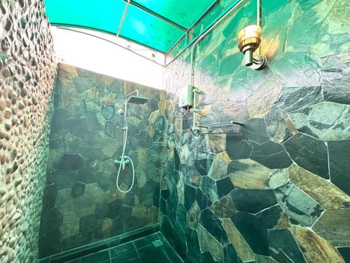 a bathroom with a shower with a stone wall at 6Pax House 6mins walk BTS,15mins drive DMK airport in Bangkok