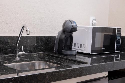 a coffee maker sitting on top of a microwave at Loft Coração da Serra in Serra Negra