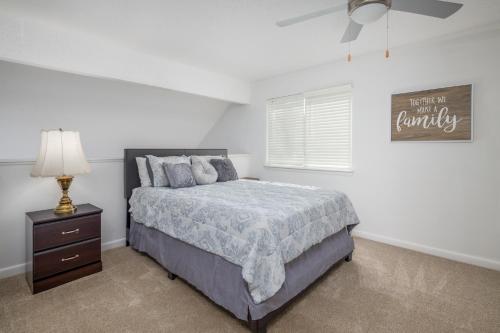 a white bedroom with a bed and a night stand at Lofy Haven at the Windsor in Huntsville