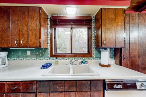 eine Küche mit einem Waschbecken und einem Fenster in der Unterkunft Roger's Place in Rhinelander