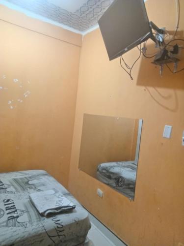 - une chambre avec un lit et un miroir dans l'établissement HOSPEDAJE MARISCAL CASTILLA, à Tumbes