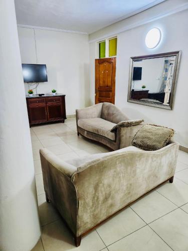 Private Rooms In Osu في آكرا: غرفة معيشة مع أريكة وكرسي