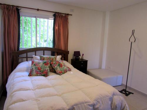 a bedroom with a large bed with a window at Encantador Departamento en Mendoza Domaine Laborde II in Mendoza