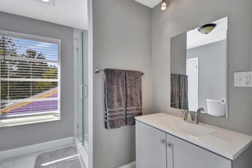 a white bathroom with a sink and a mirror at Jensen Beach Tropical Resort in Fort Pierce